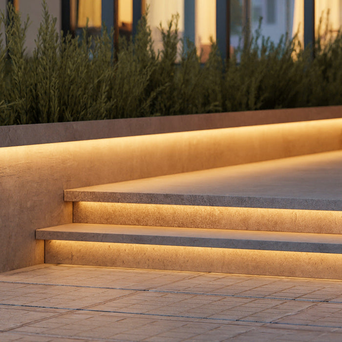 Recessed LED strip lights glowing under stair treads at night — Under-Tread Stair Lighting — Touched Home