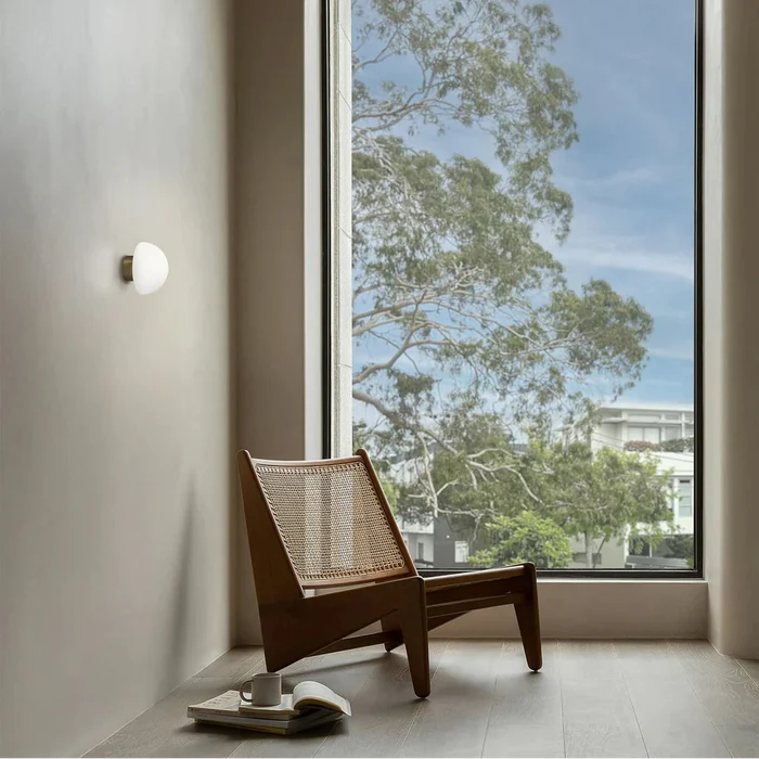 Dome Deco Wall Light installed in modern interior beside large window and lounge chair