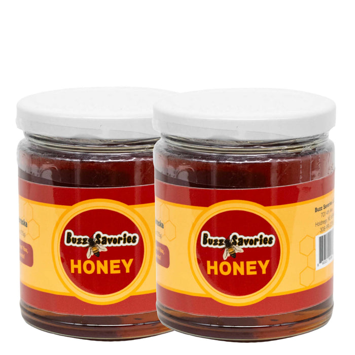 Two jars of Buzzy Zaveries honey on a white background