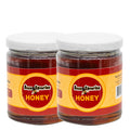 Two jars of Buzzy Zaveries honey on a white background