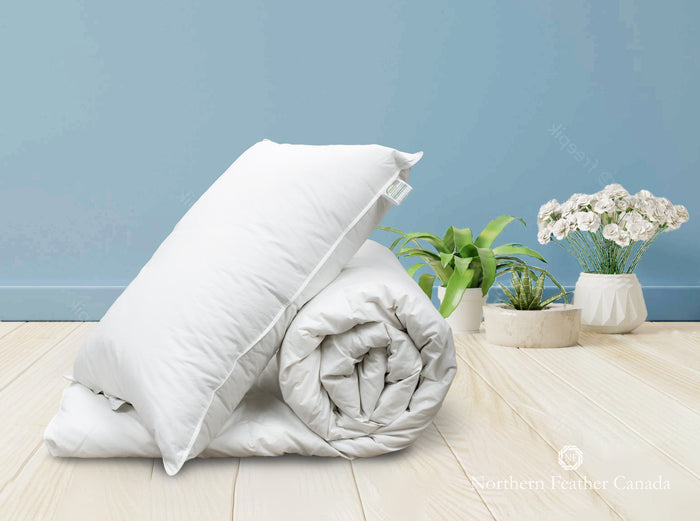 Hotel Collection 80% down & 20% feather pillow (medium fill) resting against a rolled up Hotel Collection 80% down & 20% feather Duvet (level 2 fill)