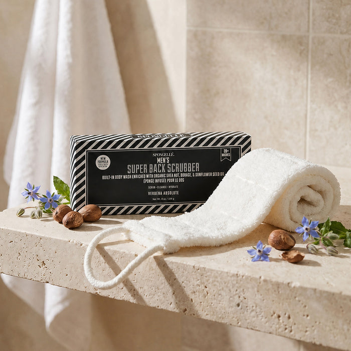 Men's Super Back Scrubber body wash with sponge on marble surface surrounded by flowers and nuts